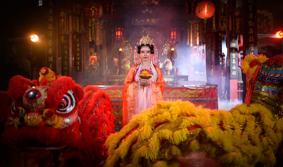 Mujer con vestido tradicional chino en la danza de los leones chinos