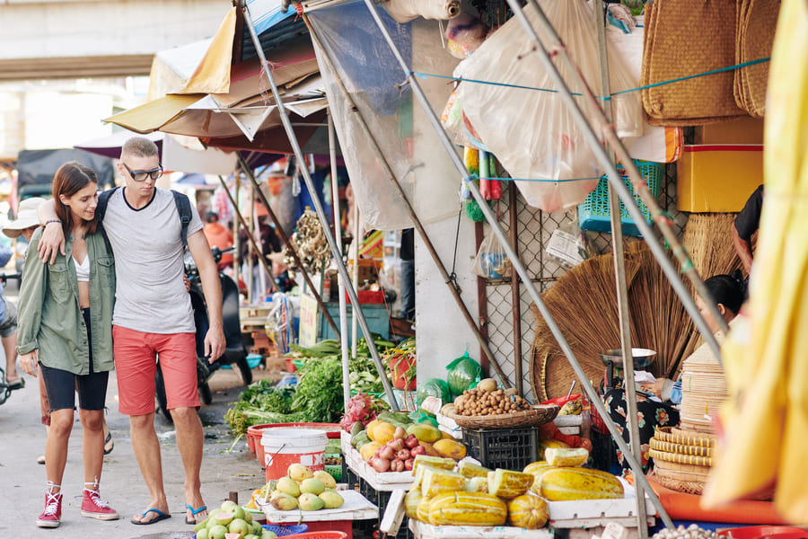 Mercado chino con un hombre y una mujer caminando abrazados